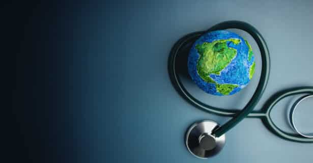 A stethoscope wraps around a painted sphere of the Earth.