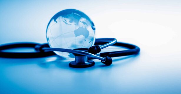 A stethoscope on a table wrapped around a globe